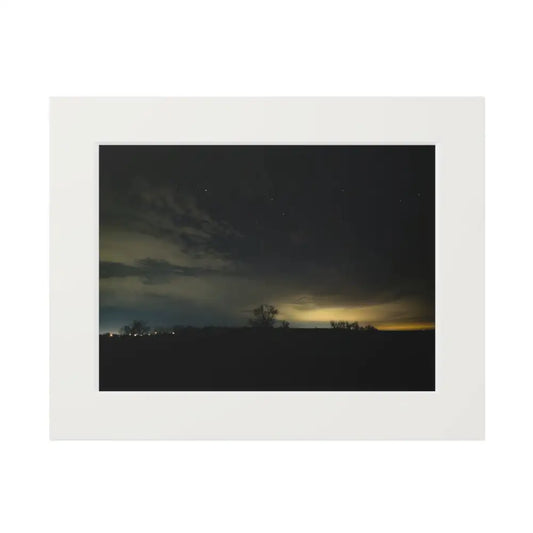 Framed photograph of a night sky with stars and clouds, featuring a white border.